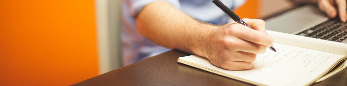 homme écrivant sur un cahier
